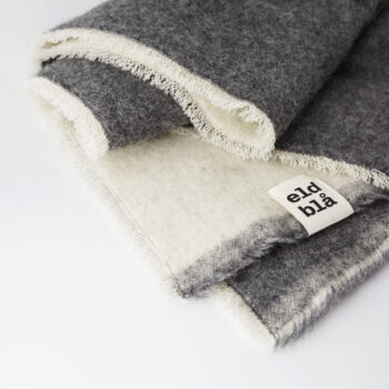 Veckad yllefilt med en mörk och en ljus sida och märkt Eldblå.