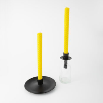 Ljusstakar i svartlackat järn, en med fat under ljushållaren och en som fästs i flaska.