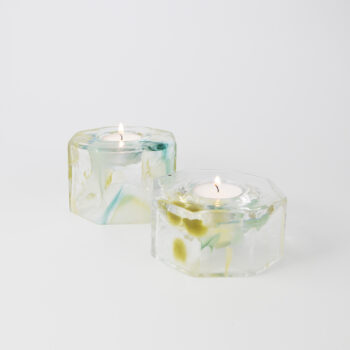 Två glasljusstakar med färgsjok för värmeljus.