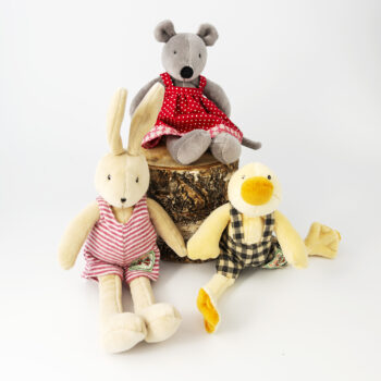 Leksaksdjur, en mus i klänning, en kanin i hängselbyxor och en anka i hängselbyxor.